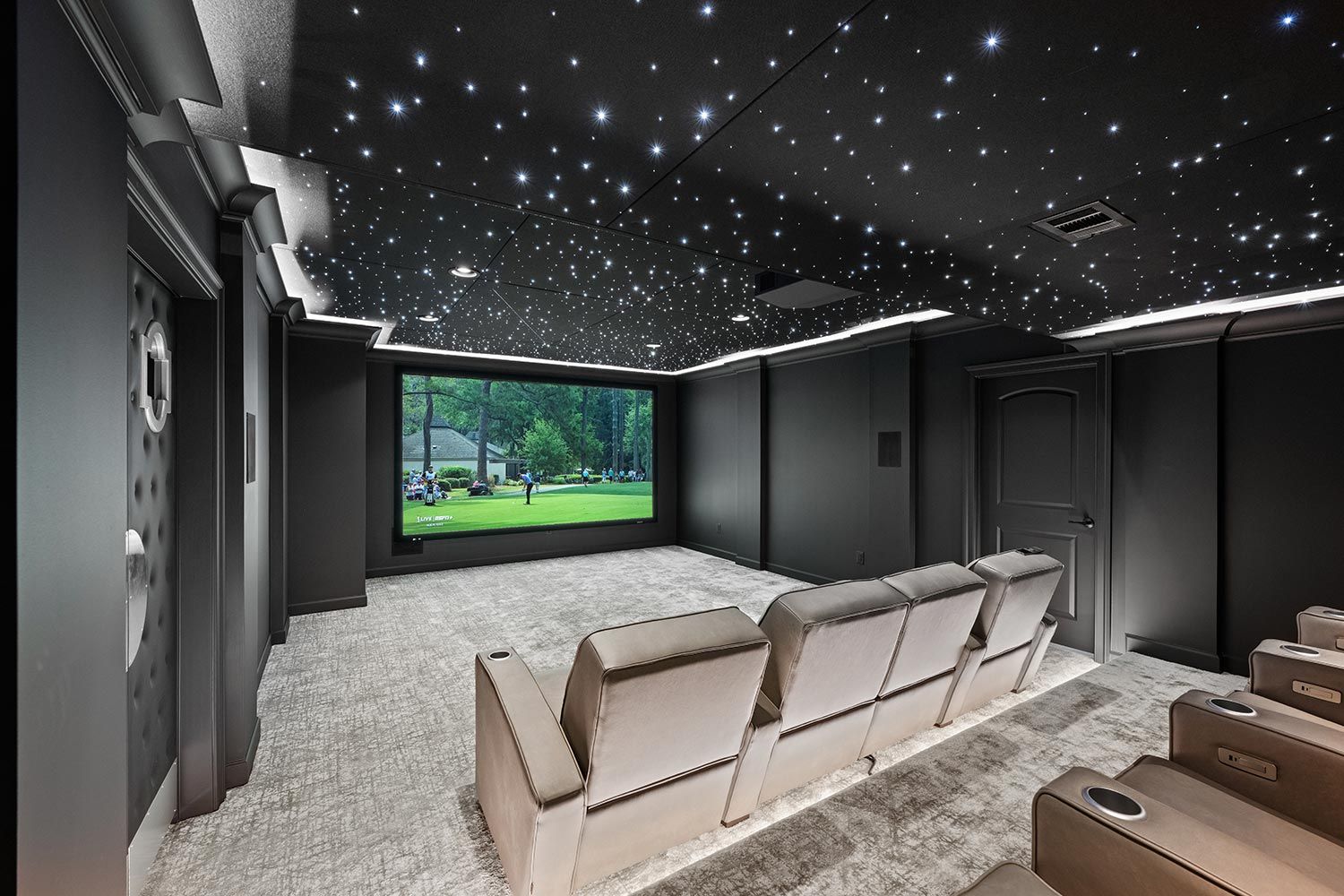 Modern home theater setup with a large screen, surrounded by a starry ceiling, providing a luxurious and immersive movie-watching experience.