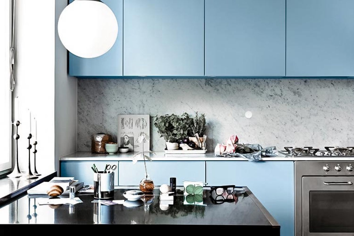 Modern kitchen with blue cabinets, marble backsplash with Josh.ai Nano, and various kitchen items on the counter.