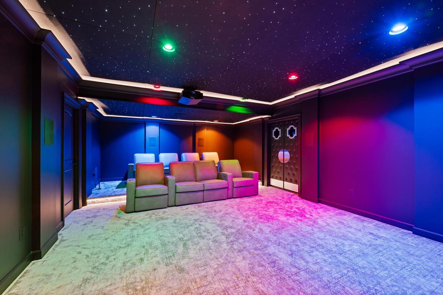 Vibrant home theater room featuring colorful ambient lighting and a starry ceiling, creating a dynamic and engaging viewing environment.